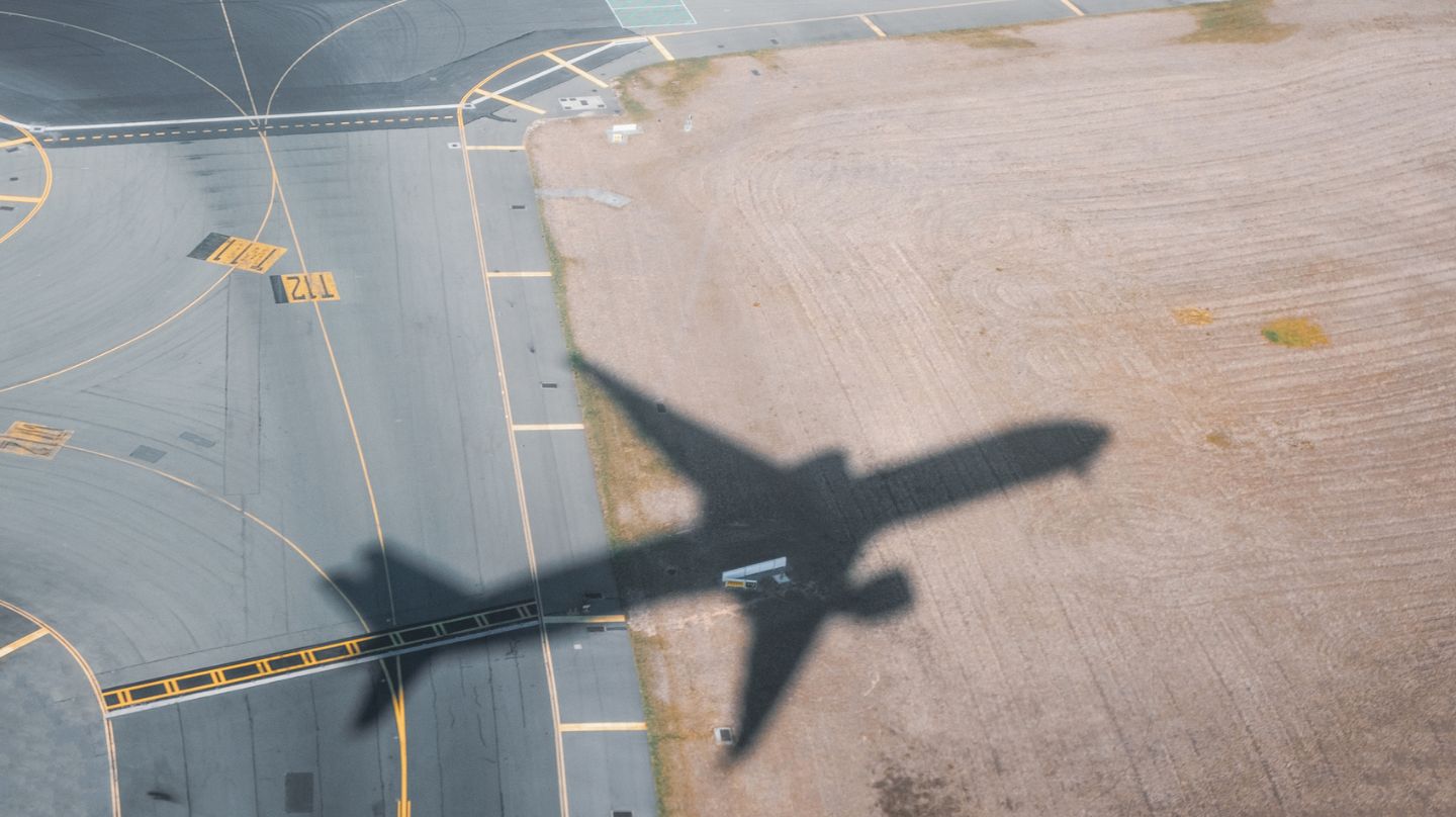 L'ombre d'un avion sur le tarmac.