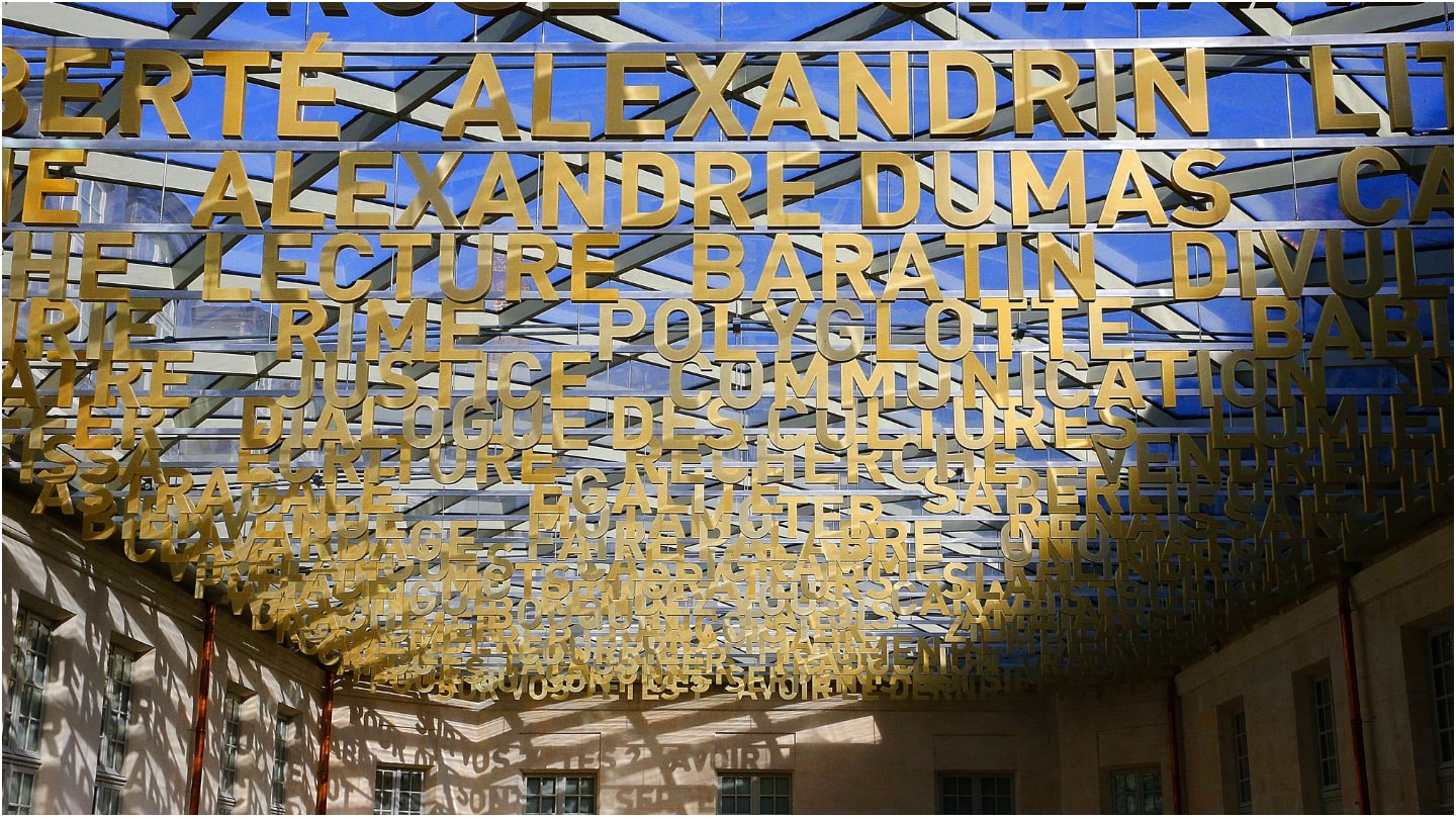 Un gros plan sur le plafond de la Cité internationale de la langue française avec des mots comme Alexandrin ou Justice.